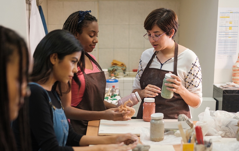 Art teacher works with high school students creating sculptures