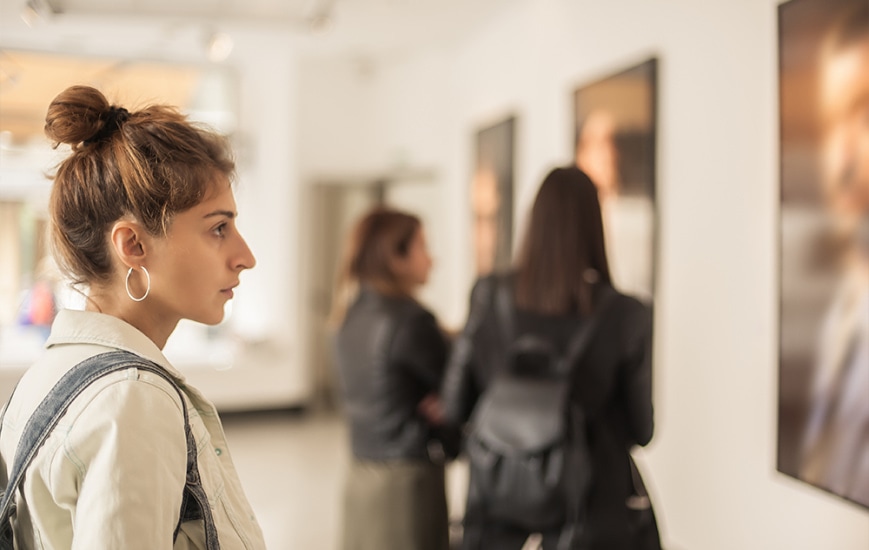 A young woman looks at a painting in an art museum