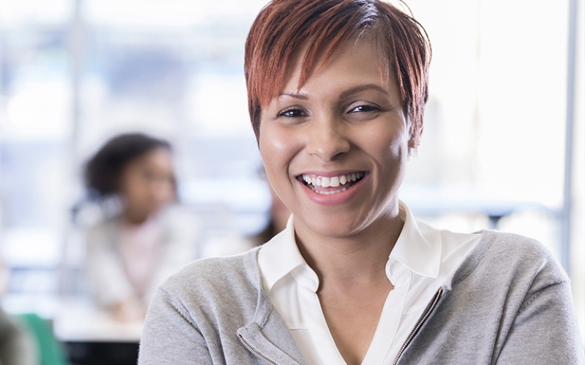 Teacher stands in front of her class smiling