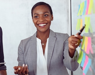 Woman pointing at whiteboard with pen