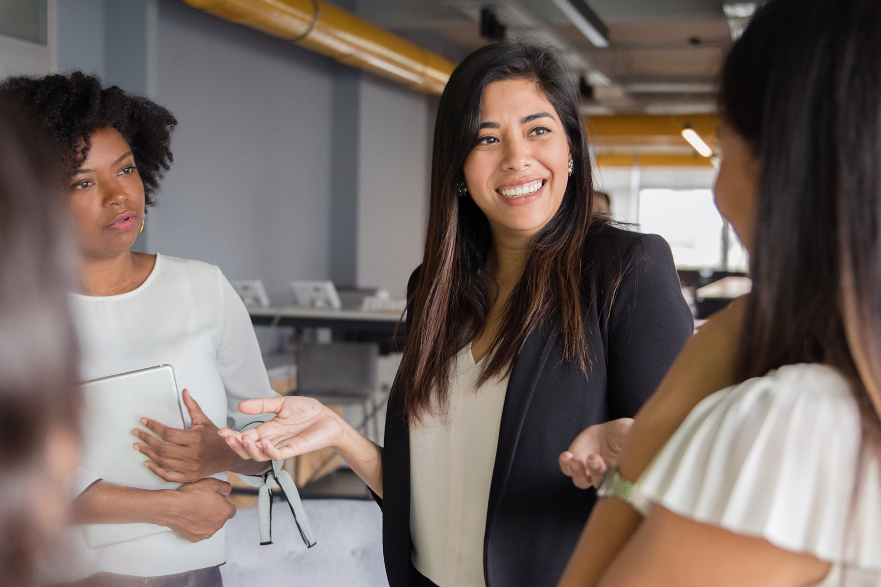 Group of alumnae in professional attire having a conversation